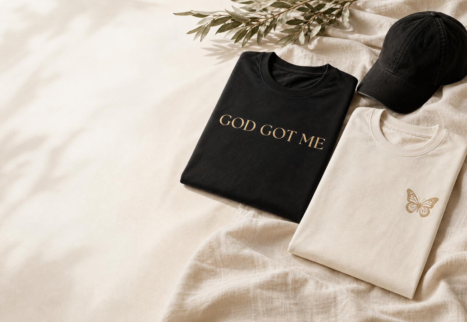 Black God Got Me tee, cream butterfly tee and black cap from UNIQUE PURPOSE APPAREL